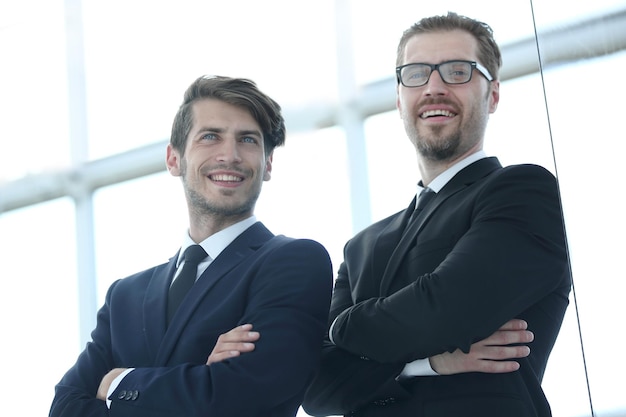 Deux hommes d'affaires souriants debout dans le concept officebusiness