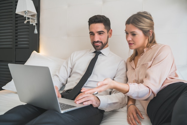 Deux hommes d'affaires travaillant ensemble sur ordinateur portable.