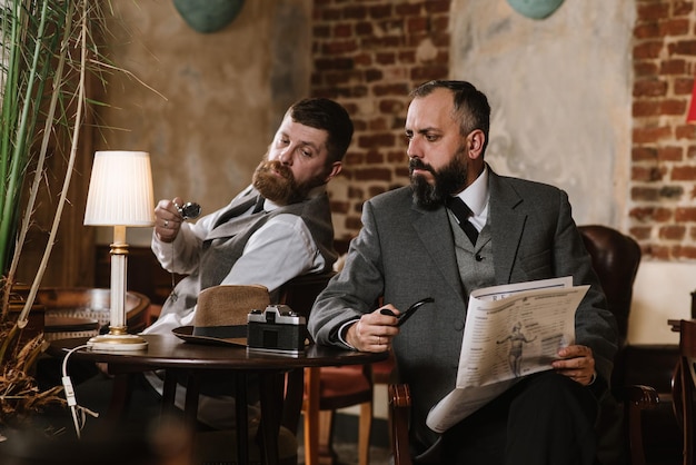 Deux hommes barbus vêtus de costumes à l'ancienne parlent ou discutent de quelque chose au restaurant