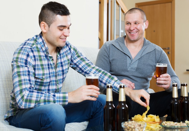 Deux hommes avec de la bière s'asseoir et parler