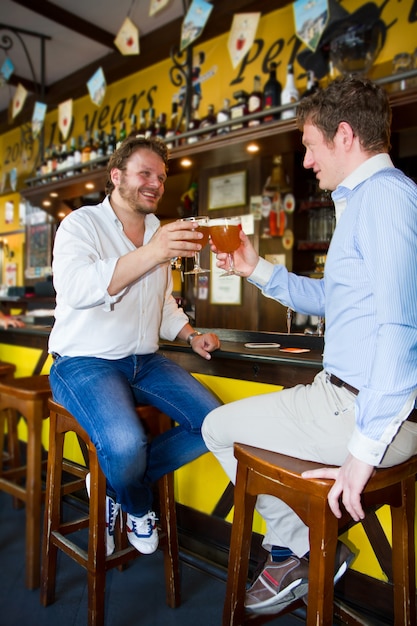 Deux hommes buvant de la bière au bar