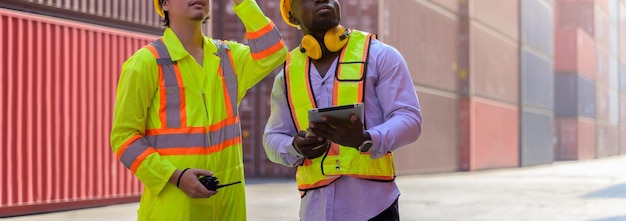 Photo deux hommes en casque de sécurité et gilet jaune travaillant ensemble au chantier naval