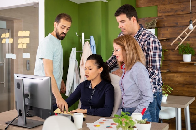 Deux hommes et deux femmes ayant une réunion dans le bureau d'une start-up moderne