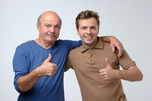 Deux hommes heureux père et fils avec le geste du pouce levé