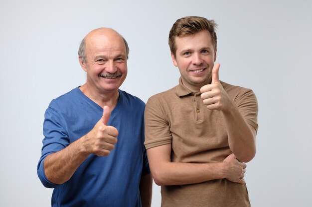 Deux hommes heureux père et fils avec le geste du pouce levé