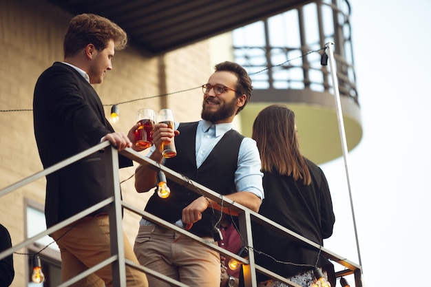 Deux hommes parlent, célèbrent, ont l'air heureux, organisent une fête d'entreprise au bureau ou au bar