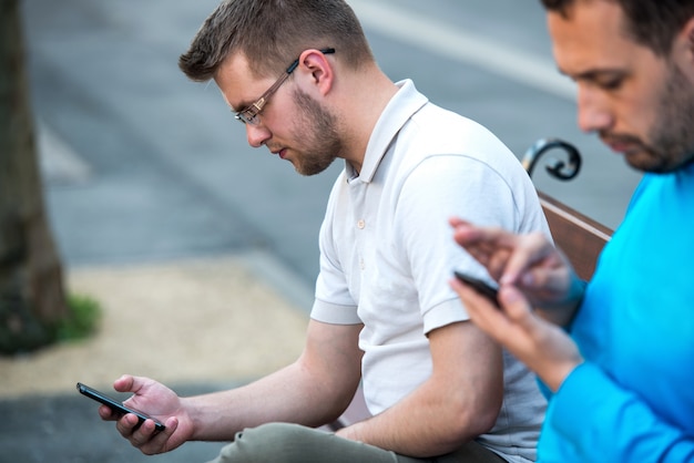 Deux hommes qui tapent sur les téléphones