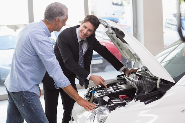 Deux hommes regardant un moteur de voiture