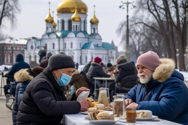 Photo deux hommes sont assis à une table avec de la nourriture et un homme portant un masque