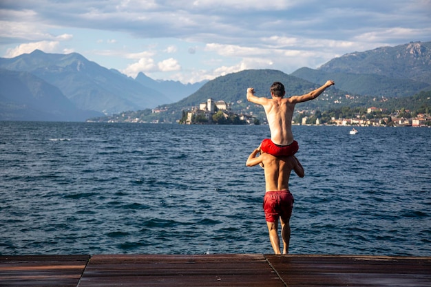 Deux hommes sont sur un quai l'un d'eux porte un short rouge et l'autre porte un short rouge