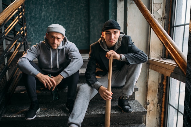 Deux hommes voleurs sont assis sur les escaliers