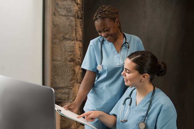 Photo deux infirmières travaillant à la clinique en gommage