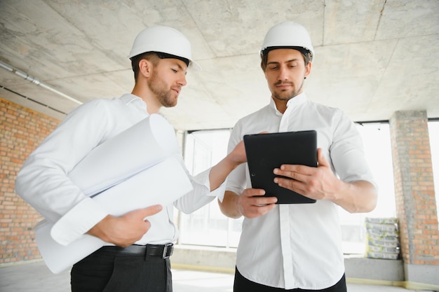 Deux ingénieurs civils ou architectes inspectant la construction d'une maison