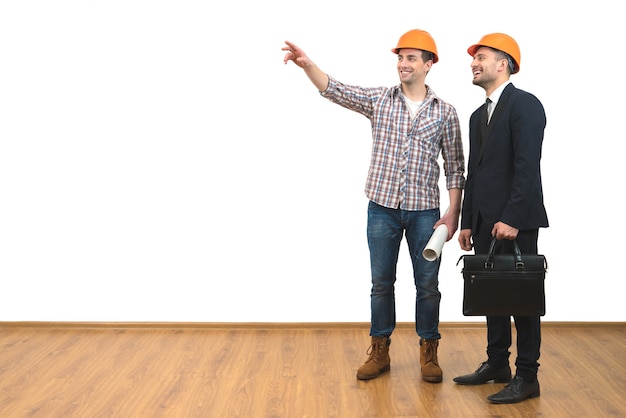 Les deux ingénieurs heureux font un geste sur le fond du mur blanc