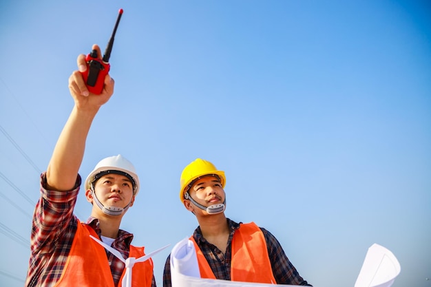 Deux ingénieurs pointent vers le projet de chantier Teamwork Leadership ciel propre en arrière-plan