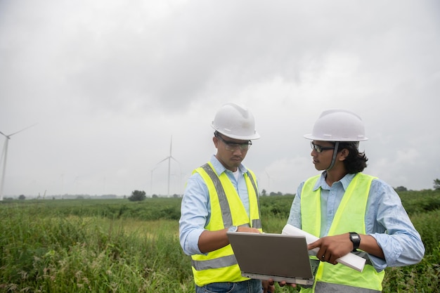 Deux ingénieurs travaillant et tenant le rapport à la centrale éolienne Power Generator Station sur mountainThailand people