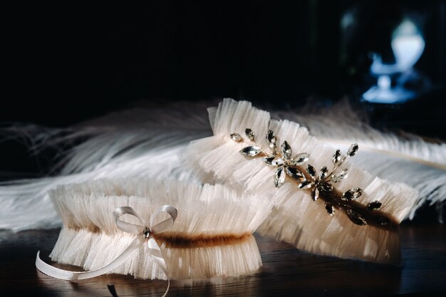 Deux jarretières blanches de la mariée sont allongées sur la table.