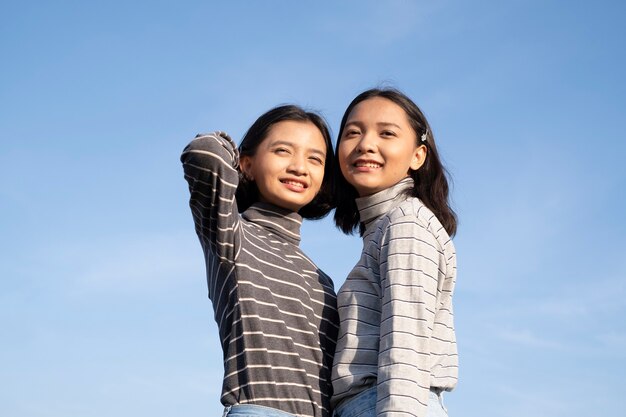 Deux jeune fille avec un ciel bleu Heureuse jeune fille