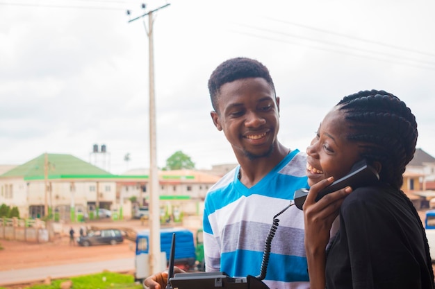 deux jeunes africains surexcités par les nouvelles qu'ils ont entendues au téléphone.