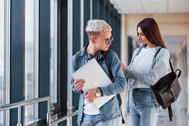 Deux jeunes amis étudiants ensemble dans un couloir d'un collège