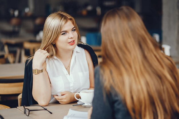 deux jeunes et belle femme d&#39;affaires assis dans un café et de travail