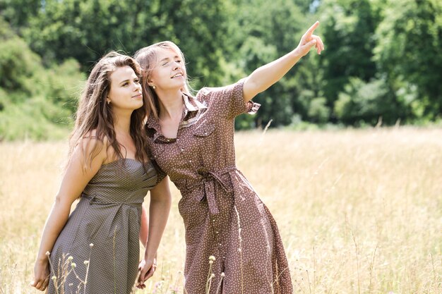 Deux jeunes belles filles gaies s'amusant sur le pré dans le parc