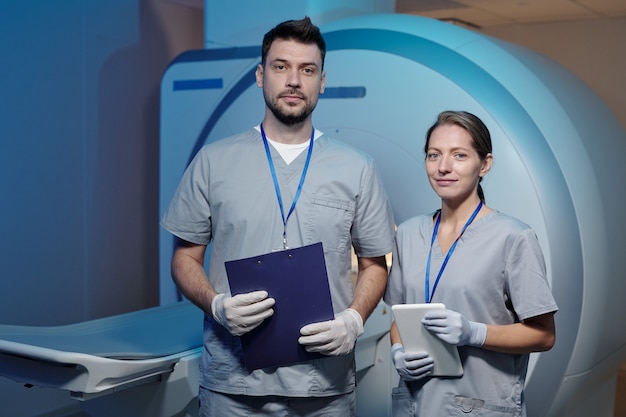 Deux jeunes cliniciens confiants en uniforme et gants