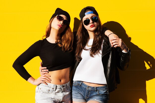 Deux jeunes copines en lunettes de soleil s'amusant. Mode de vie.