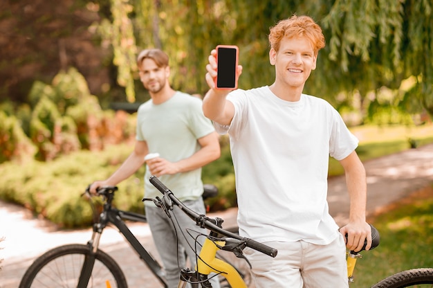 Deux jeunes cyclistes debout dans un parc