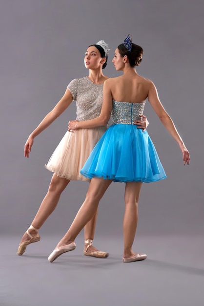 Deux jeunes danseurs de ballet posant ensemble sur fond gris