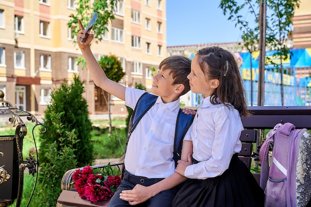 Deux jeunes écoliers prennent un selfie sur leur téléphone