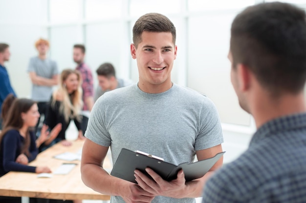 Deux jeunes employés discutant d'un document commercial