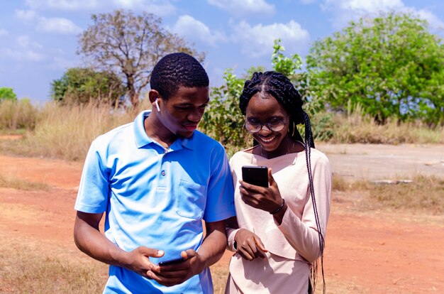 Deux jeunes étudiants africains se sentent enthousiasmés par ce qu'ils ont vu sur leur téléphone portable