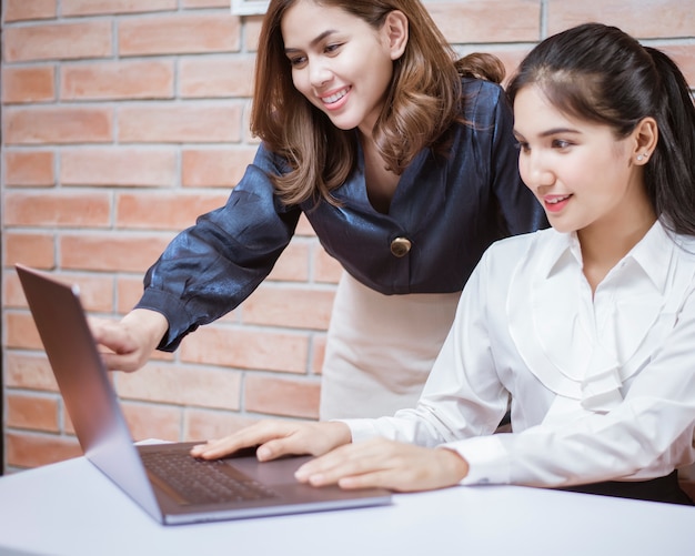 Deux Jeunes Femmes D'affaires Sont Des Informations Analytiques Sur écran D'ordinateur Portable, Réunion D'affaires