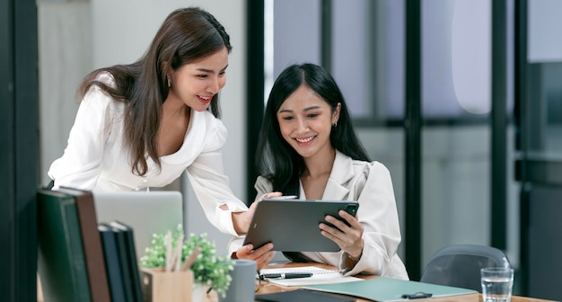 Deux jeunes femmes d'affaires souriantes discutent avec un nouveau projet de démarrage Présentation d'idées et marché de l'investissement au bureau