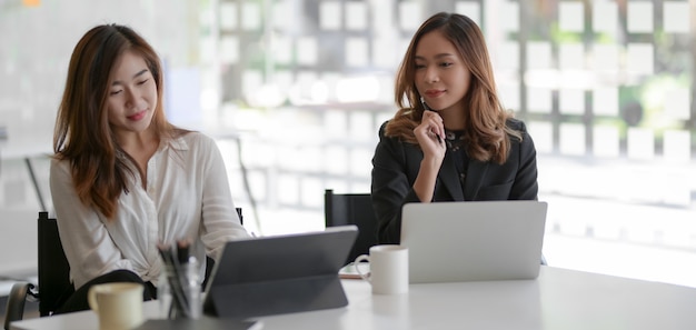 Deux jeunes femmes d'affaires travaillant ensemble sur le projet marketing