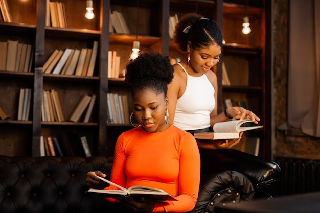 deux jeunes femmes africaines lisant des livres dans la bibliothèque