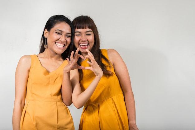 deux jeunes femmes asiatiques ensemble contre l'espace blanc