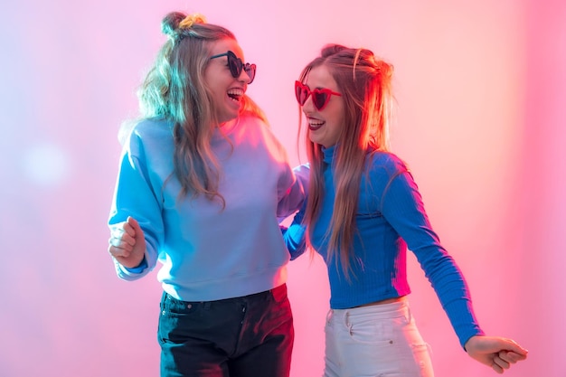 Deux jeunes femmes caucasiennes blondes dansant dans une discothèque ayant beaucoup de plaisir à danser