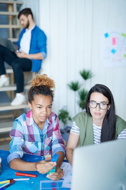 Deux jeunes femmes créatives travaillant avec ordinateur