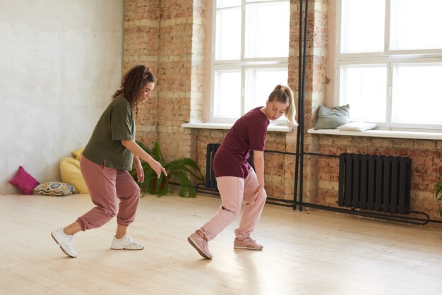 Deux jeunes femmes dansant ensemble ils apprennent une nouvelle danse en studio de danse