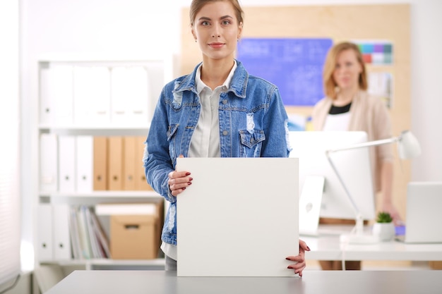 Deux jeunes femmes debout près du bureau avec plan d'instruments et ordinateur portable