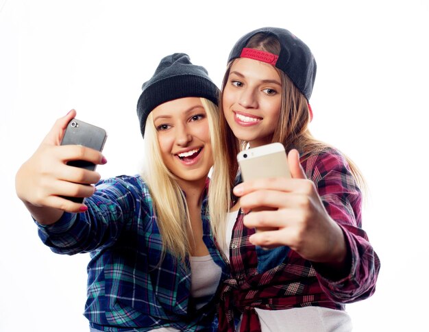 Deux jeunes femmes drôles prenant le selfie avec le téléphone portable