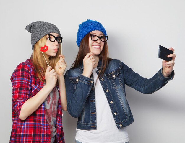 Deux jeunes femmes drôles prenant le selfie avec le téléphone portable