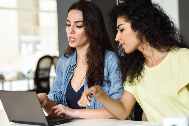 Deux jeunes femmes étudient avec un ordinateur portable.