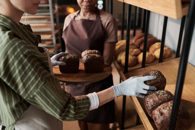 Deux jeunes femmes faisant du pain qu'elles travaillent dans la boulangerie