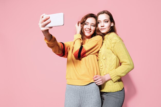 Deux jeunes femmes gaies parler selfie