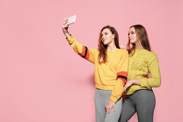 Deux jeunes femmes gaies parler selfie