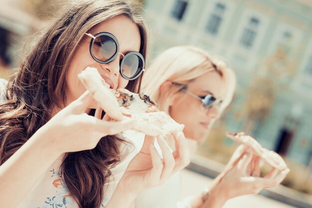 Deux jeunes femmes mangeant de la pizza