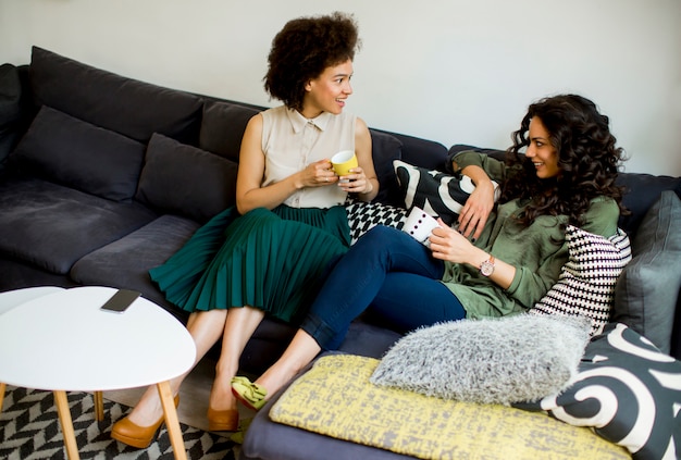 Deux jeunes femmes multiraciales discutant et buvant du café